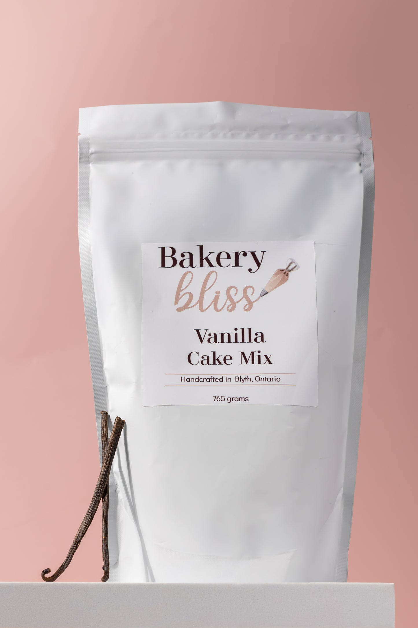 Bakery bliss Vanilla Cake Mix packaging with a vanilla bean on a pink background