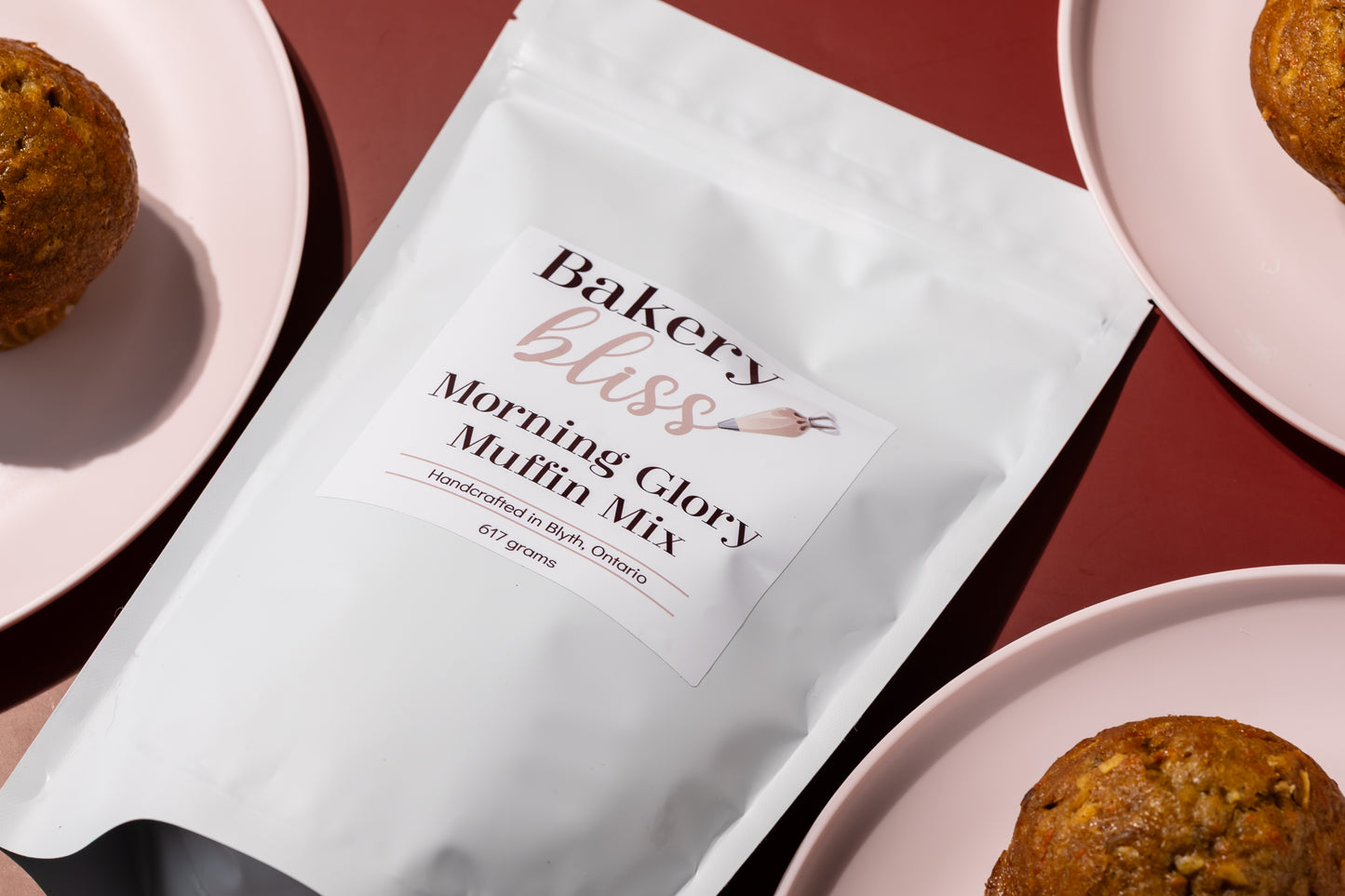 Bakery bliss Morning Glory Muffin Mix package with muffins on pink plates.
