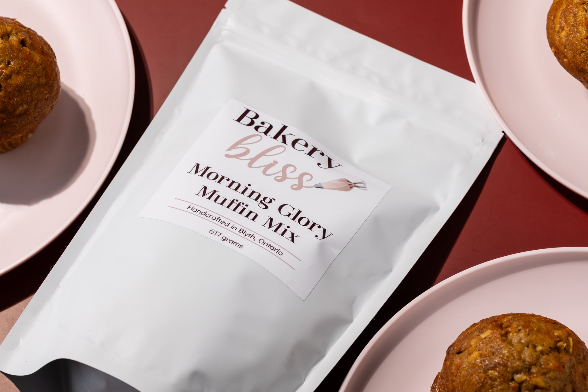 Bakery bliss Morning Glory Muffin Mix package with muffins on pink plates.