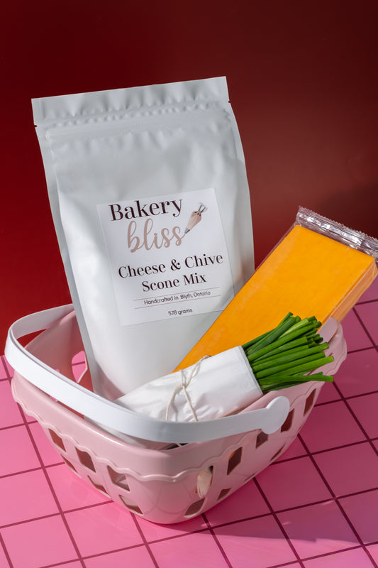 Bakery bliss cheese and chive scone mix in a pink basket on a red and pink checkered background