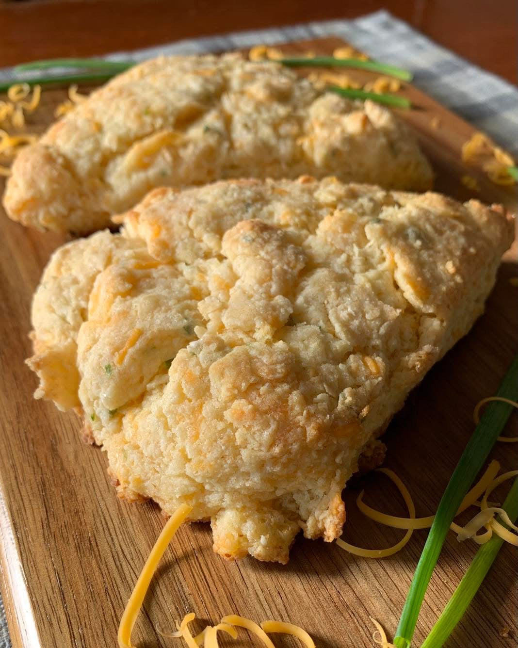 Cheesy scones on a wooden board with green onions