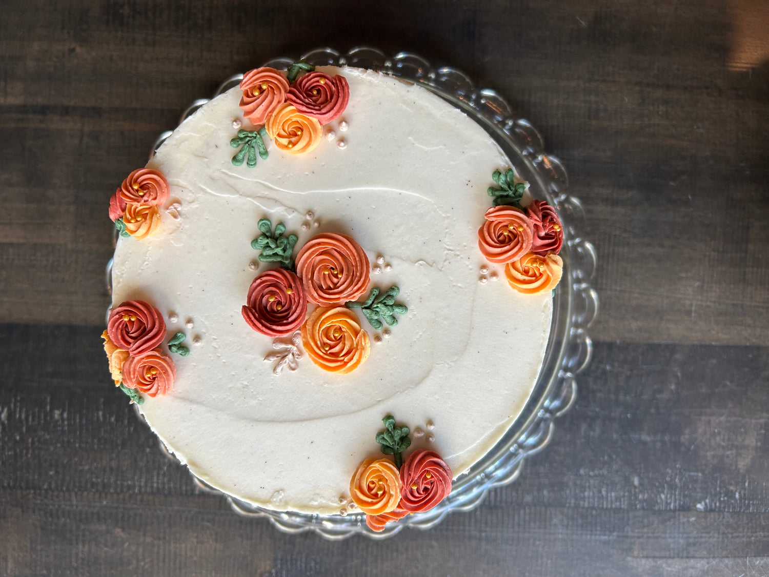 Decorative cake with floral designs on a glass plate