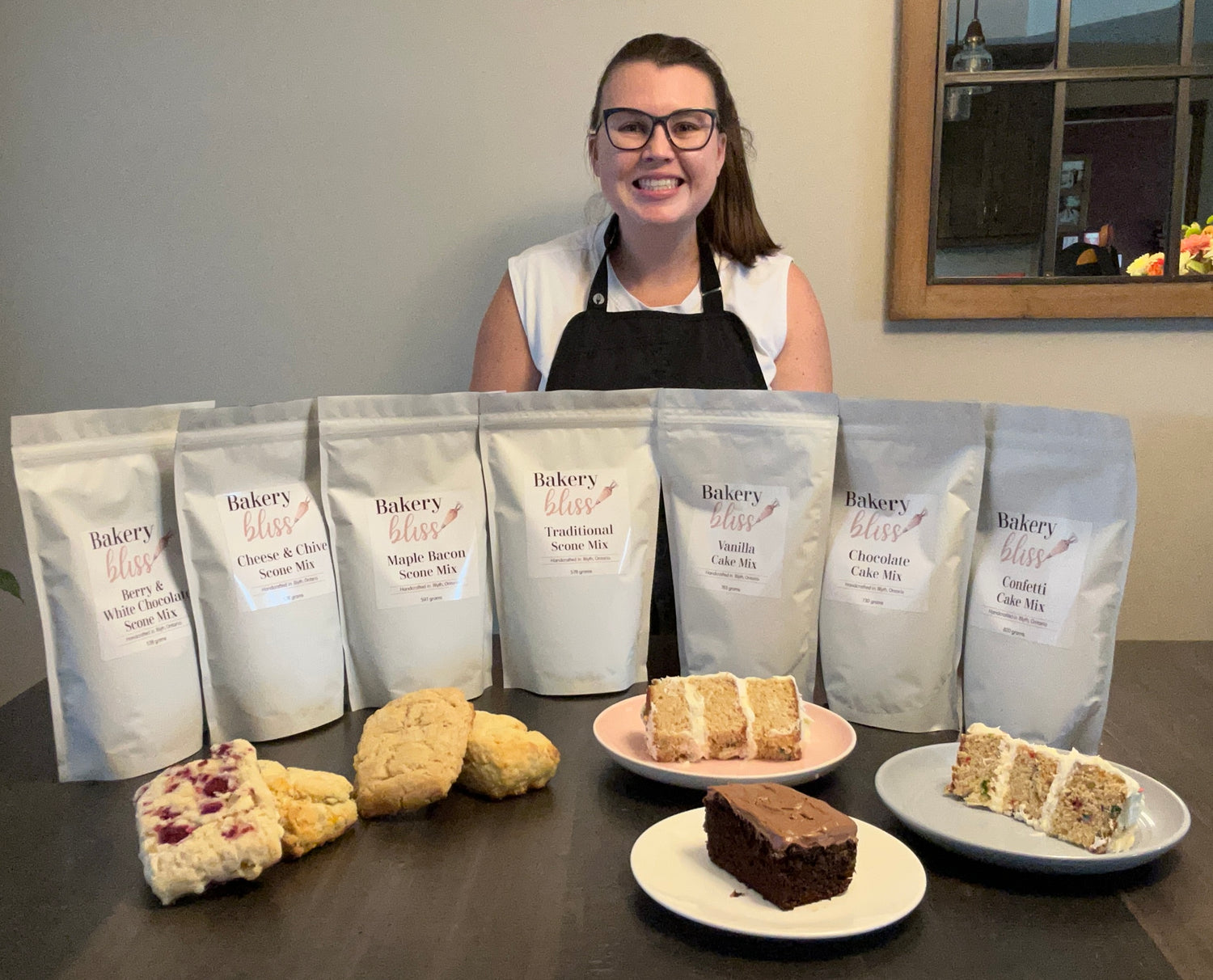 Jessica in an apron with Bakery Bliss product display on a table